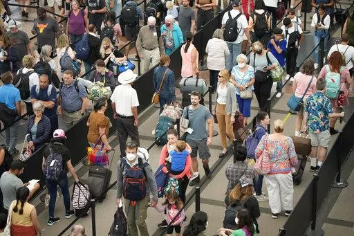 Travelers queue up at the south security checkpoint in Denver International Airport as the Labor Day holiday approaches Tuesday, Aug. 30, 2022, in Denver.  If you want to save money and avoid the airport crowds during the holiday season, you’ll want to fly on the holiday itself or several days before and after it. NerdWallet analyzed the Transportation Security Administration’s data of passengers screened at U.S. airports and found the Sunday after Thanksgiving and Dec. 23 to be two of the b