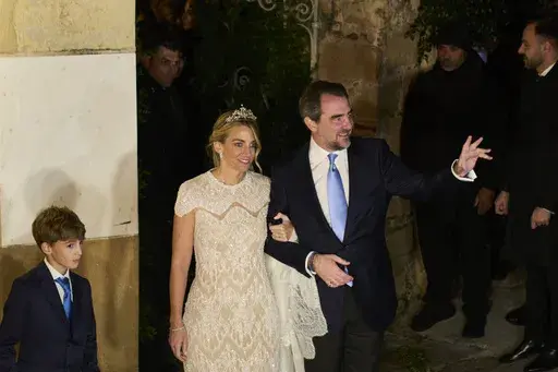 Nikolaos De Grece, son of Greece's late former King Constantine II, and Chrysi Vardinogianni leave the Orthodox Church of Saint Nicholas Ragavas in Athens' historic Plaka district after getting married, on Friday Feb. 7, 2025. (AP Photo/Petros Giannakouris)