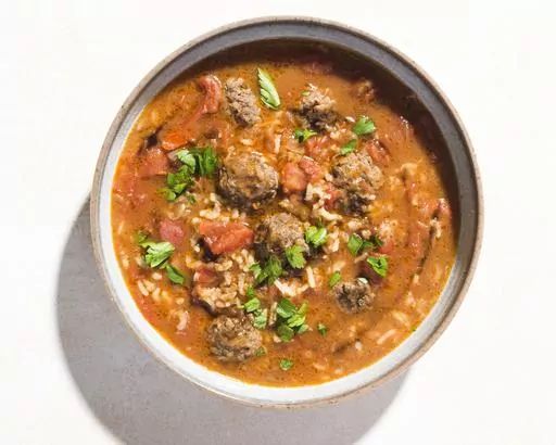 This image released by Milk Street shows a recipe for Syrian-style Meatball Soup w/Rice and Tomatoes. (Milk Street via AP)