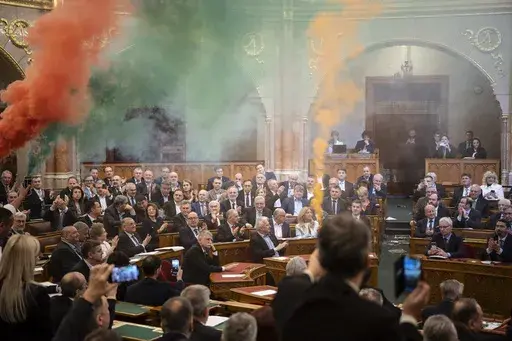 MPs of Momentum protest with flares during the plenary session of the Hungarian parliament in Budapest, Hungary, Tuesday, March 18, 2025. (Boglarka Bodnar/MTI via AP)