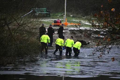 Police search teams at the scene after children fell through ice,in Babbs Mill Park in Kingshurst, Solihull, England, Monday, Dec. 12, 2022. Three young boys who fell through ice covering a lake in central England have died and a fourth remains hospitalized as weather forecasters issued severe weather warnings for large parts of the United Kingdom. Rescuers pulled the boys, aged 8, 10 and 11, from the icy waters Sunday afternoon and rushed them to the hospital in the West Midlands, about 100 mil