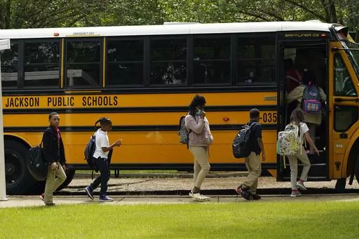 Spann Elementary School students board a school bus following a full day of in-school learning, Sept. 6, 2022, in Jackson, Miss. After the COVID-19 pandemic disrupted schools around the country and led to more children missing classes, the number of students who were chronically absent in Mississippi declined during the most recent school year, according to data released, Tuesday, Sept. 26, 2023, by the state's education department. (AP Photo/Rogelio V. Solis, File)