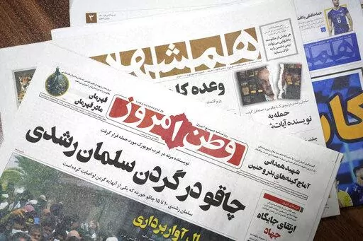 The front pages of the Aug. 13 edition of the Iranian newspapers, Vatan-e Emrooz, front, with title reading in Farsi: "Knife in the neck of Salman Rushdie," and Hamshahri, rear, with title: "Attack on writer of Satanic Verses," are pictured in Tehran Saturday, Aug. 13, 2022. Rushdie, whose novel “The Satanic Verses” drew death threats from Iran’s leader in the 1980s, was stabbed in the neck and abdomen Friday by a man who rushed the stage as the author was about to give a lecture in wester