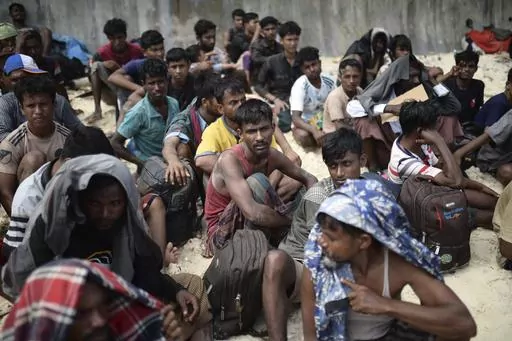 Ethnic Rohingya men sit on a beach after they landed in Sabang, Aceh province, Indonesia, Wednesday, Nov. 22, 2023. The U.N. refugee agency on Monday Dec. 4, 2023 sounded the alarm for hundreds of Rohingya Muslims believed to be aboard two boats reported to be out of supplies and adrift on the Andaman Sea. (AP Photo/Reza Saifullah, File)