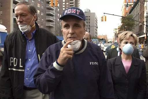 FILE — New York Mayor Rudolph Giuliani, center, leads New York Gov. George Pataki, left, and Sen. Hillary Rodham Clinton, D-N.Y., on a tour of the site of the World Trade Center disaster, Sept. 12, 2001. Giuliani, once warmly regarded as "America's Mayor" in the wake of the 9/11 attacks, and who first rose to prominence as a federal prosecutor going after mobsters with a then-novel approach to racketeering cases, has seen his reputation tumble and his liberty threatened in defense of Donald Tr