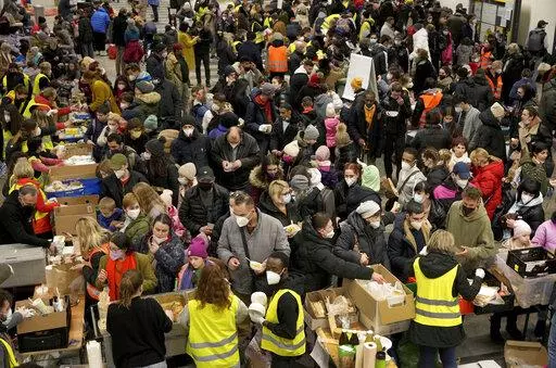 Ukrainian refugees queue for food in the welcome area after their arrival at the main train station in Berlin, Germany, March 8, 2022. The Ukraine war has turned the basement of Berlin’s glass-and-steel main train station into a sprawling refugee town where a small army of volunteers in yellow and orange vests offer everything from shampoo to cell phone chargers to exhausted refugees. (AP Photo/Michael Sohn, File)