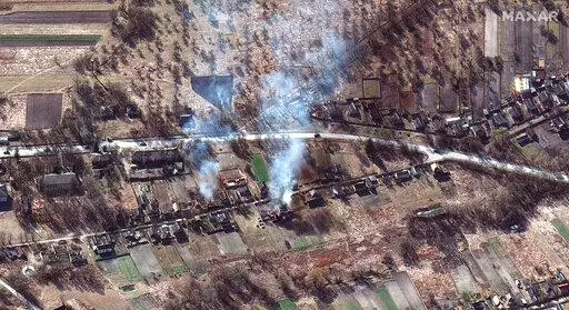 This satellite image provided by Maxar Technologies shows part of military convoy and burning homes northwest of Invankiv, Ukraine Monday, Feb. 28, 2022. (Satellite image ©2022 Maxar Technologies via AP)