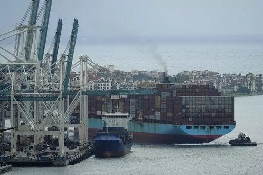 Tugboats guide the Axel Maersk container ship as it arrives into port, Oct. 21, 2021, in Miami. The marine shipping industry is facing new regulations to address carbon pollution. Its trade groups have been seeking exemptions for pollution emitted during voyages on rough seas. (AP Photo/Rebecca Blackwell, File)