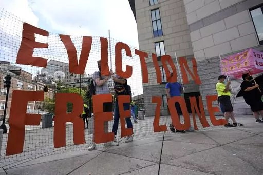 In this June 9, 2021, photo, people hold a sign during a rally in Boston protesting housing eviction. Housing advocates are raising the alarm about House Republicans' plan to dramatically cut the federal deficit to raise the debt ceiling, warning that struggling families could lose access to rental aid. (AP Photo/Elise Amendola, File)