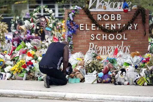Reggie Daniels pays his respects a memorial at Robb Elementary School on June 9, 2022, in Uvalde, Texas. Nearly 400 law enforcement officials rushed to the mass shooting that left 21 people dead at the elementary school but “systemic failures” created a chaotic scene that lasted more than an hour before the gunman was finally confronted and killed, according to a report from investigators released Sunday, July 17, 2022. (AP Photo/Eric Gay, File)