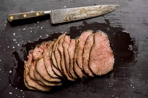 This image released by Milk Street shows a recipe for prune, peppercorn and fresh herb-rubbed roast beef. (Milk Street via AP)