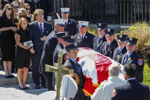 Patrick and Dee Dee Klein, parents of late New York City Firefighter (FDNY) Timothy Klein, follow his casket as it is carried out of St. Francis DeSales Church during a funeral service, Friday, April 29, 2022, in New York. Klein, 31, died Sunday when flames engulfed the second floor of the home, causing part of the ceiling to collapse. (AP Photo/Eduardo Munoz Alvarez)