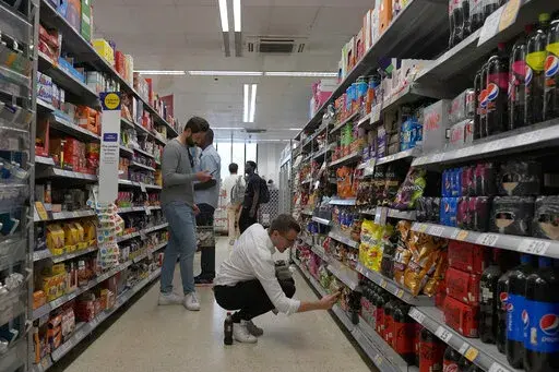 Shoppers buy food in a supermarket in London, Wednesday, Aug. 17, 2022. Britain’s new Prime Minister Liz Truss has pledged to rebuild the economy, but she faces a daunting job. Truss inherits an ailing economy on the brink of a potentially long recession, with record inflation and millions crying out for government help to cope with energy bills. (AP Photo/Frank Augstein, File)