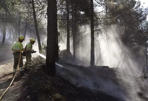 Firefighters try to extinguish a forest fire in Fuente la Reina, Castellon de la Plana, Spain, March 29, 2023. Spain suffered the biggest losses from wildfires of any European Union country last year amid a record-hot 2022, and there is worry that this year’s fire season could also be bad. (AP Photo/Alberto Saiz, File)