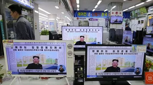 A man walks past TV monitors displaying a news program at an electronic shop in Seoul, South Korea, on Oct. 14, 2014, showing a North Korean newspaper with a photo of North Korean leader Kim Jong Un smiling, reportedly during his first public appearance in five weeks in Pyongyang, North Korea. The writing reads, "Honorable Kim Jong Un." South Korea plans to lift its decades-long ban on public access to North Korean television, newspapers and other media as part of its efforts to promote mutual u