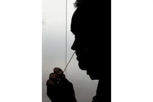 FILE - A rapid COVID-19 test is taken, Wednesday, Nov. 18, 2020, in Salt Lake City. President Joe Biden says the federal government will buy half a billion COVID-19 rapid test kits and distribute them free of charge to people to use at home. Delivery of the first batch of the 500 million tests isn't expected until early January 2022. (AP Photo/Rick Bowmer, File)