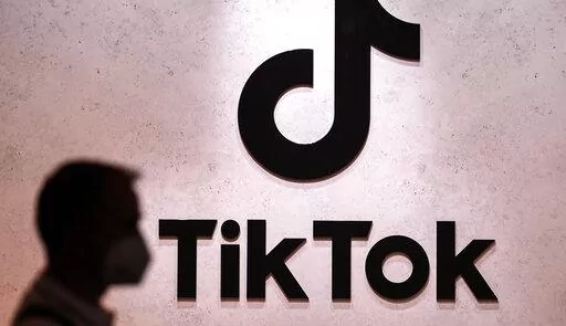 A visitor passes the TikTok exhibition stands at the Gamescom computer gaming fair in Cologne, Germany, Aug. 25, 2022. The European Union's digital policy chief warned TikTok's boss Thursday, Jan. 19, 2023 that the social media app will have to fall in line with tough new rules for online platforms set to take effect later this year. EU Commissioner Thierry Breton held a video call with Shou Zi Chew, the CEO of TikTok, the popular Chinese-owned video sharing app that's coming under increasing sc