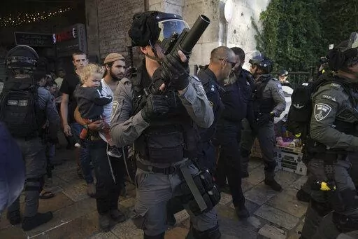 Israeli security forces escort a group of Jews outside Damascus Gate, in Jerusalem's Old City, Wednesday, April 20, 2022. Police prevented hundreds of ultra-nationalist Israelis from marching around predominantly Palestinian areas of Jerusalem's Old City. The event planned for Wednesday was similar to one that served as one of the triggers of last year's Israel-Gaza war. (AP Photo/Mahmoud Illean)