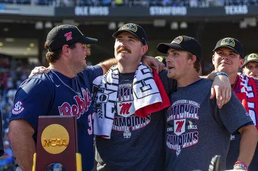 Mississippi's Ben Van Cleve (33), Tim Elko (25) and Justin Bench (8) look on during the closing video after a win over Oklahoma in Game 2 of the NCAA College World Series baseball finals, Sunday, June 26, 2022, in Omaha, Neb. (AP Photo/John Peterson)