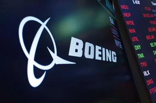 The logo for Boeing appears on a screen above a trading post on the floor of the New York Stock Exchange, July 13, 2021. Boeing says the head of its 737 jetliner program is leaving the company immediately, paving the way for the aircraft maker to appoint new leadership at the troubled division. (AP Photo/Richard Drew, File)