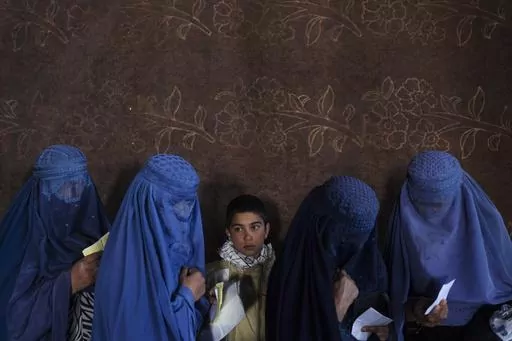 Afghan women wait to receive cash at a money distribution point organized by the World Food Program, in Kabul, Afghanistan, on Nov. 20, 2021. The United Nations has been forced to cut food, cash payments and assistance to millions of people in many countries because of “a crippling funding crisis” that has seen its donations plummet by about half as acute hunger is hitting record levels, a top official said Friday, July 28, 2023. (AP Photo/Petros Giannakouris, File)