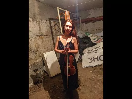 CORRECTS SPELLING OF NAME  Vera Lytovchenko holds her violin as she poses for a photo in a basement of an apartment building in Kharkiv, Ukraine, Sunday March 6, 2022. Lytovchenko is Ukraine's cellar violinist, who has become an internet icon of resilience as images of her playing in the basement bomb shelter have inspired an international audience via social media. (Vera Lytovchenko via AP)